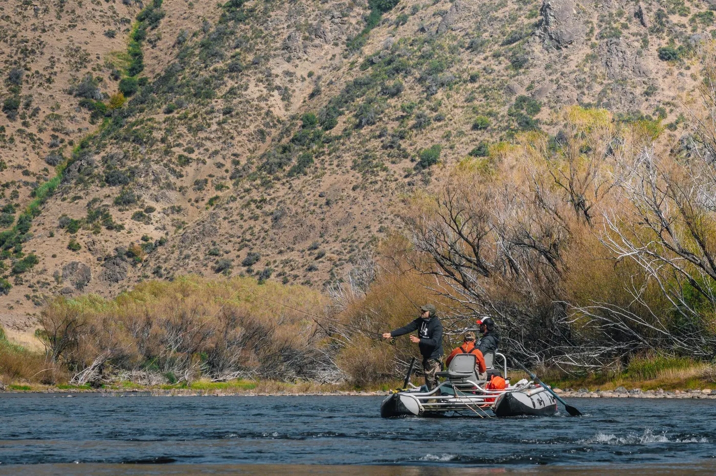 Fly fisherman casting in a Patagonian river at sunrise